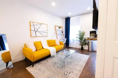 a living room with a yellow couch and a glass table at 69-3C Stylish Lower East East 1br Apt BRAND NEW in New York