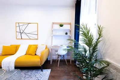 a living room with a yellow couch and a desk at 69-3C Stylish Lower East East 1br Apt BRAND NEW in New York