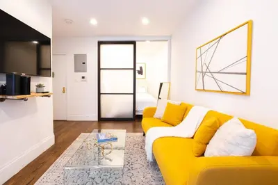 a living room with a yellow couch and a table at 69-3C Stylish Lower East East 1br Apt BRAND NEW in New York