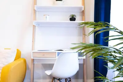 a white desk with a chair and a plant at 69-3C Stylish Lower East East 1br Apt BRAND NEW in New York