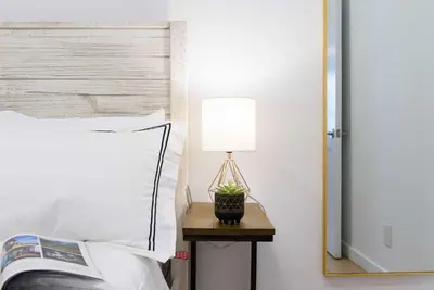 a lamp on a table next to a bed at 69-3D Prime Lower East East BRAND NEW 1br Apt in New York