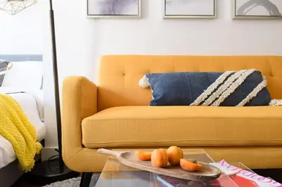 a living room with a yellow couch and a plate of oranges at 24-16 Studio Gramercy W D gramercy in New York