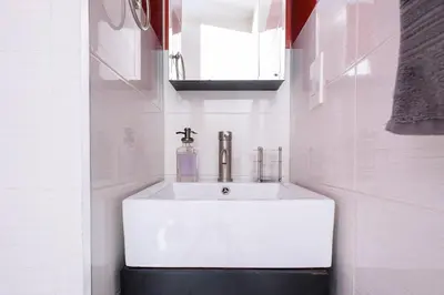 a white sink in a white tiled bathroom at 24-16 Studio Gramercy W D gramercy in New York