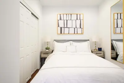 a white bedroom with a bed and a mirror at 69-4A Quality NEW Prime Lower East East 1br Apt in New York