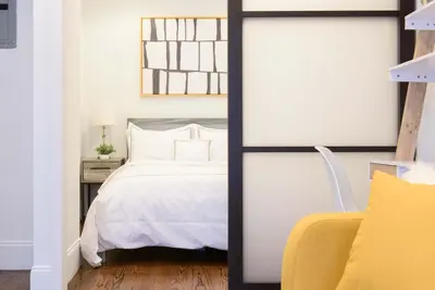 a bedroom with a white bed and a yellow chair at 69-4A Quality NEW Prime Lower East East 1br Apt in New York