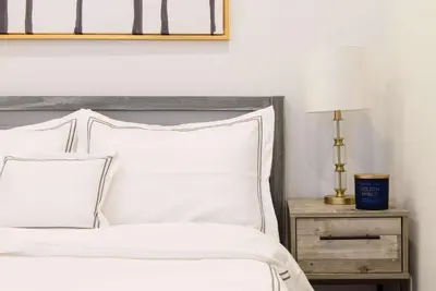 a bedroom with a white bed and a table with a lamp at 69-4A Quality NEW Prime Lower East East 1br Apt in New York