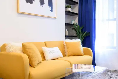 a yellow couch in a living room with a table at 69-4A Quality NEW Prime Lower East East 1br Apt in New York