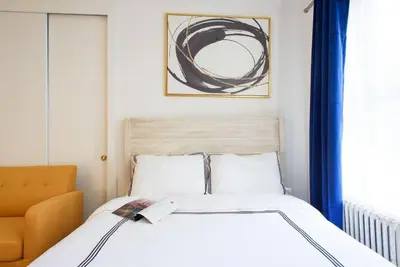 a bedroom with a bed and a orange chair at 24-17 Renovated Studio Prime Location WD in New York