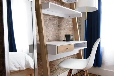 a bedroom with a white desk and a chair at 24-18 New Gramercy Studio W D in Unit Fully Reno in New York