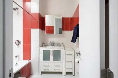 a bathroom with a white sink and red and white walls at 24-18 New Gramercy Studio W D in Unit Fully Reno in New York