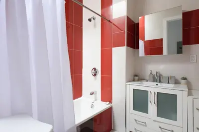 a bathroom with a white sink and red and white walls at 24-18 New Gramercy Studio W D in Unit Fully Reno in New York