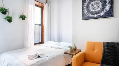 a bedroom with a bed and a chair and a window at 24-3 Prime Gramercy New Studio W D Terrace in New York
