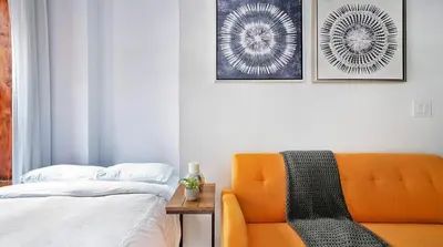 a bedroom with an orange couch and a bed at 24-3 Prime Gramercy New Studio W D Terrace in New York