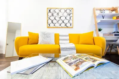 a living room with a yellow couch and a table at 69-4C PRIME Lower East Side 1br Apt Brand New in New York