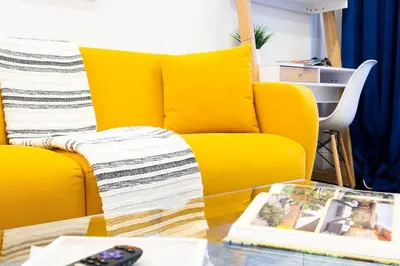 a living room with a yellow couch and a table at 69-4C PRIME Lower East Side 1br Apt Brand New in New York