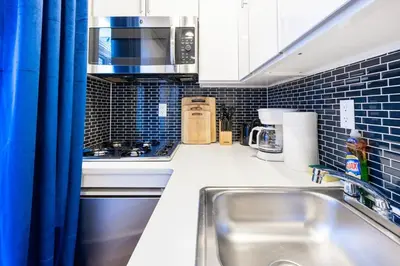 a small kitchen with a sink and a microwave at 69-4C PRIME Lower East Side 1br Apt Brand New in New York