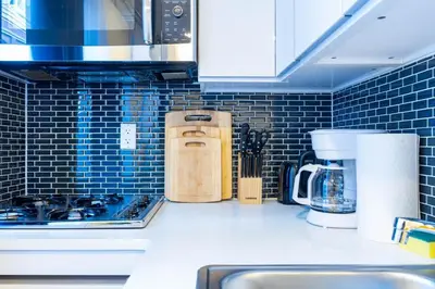 a kitchen with a counter top with blue tiles at 69-4C PRIME Lower East Side 1br Apt Brand New in New York