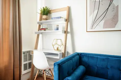 a living room with a blue couch and a white chair at 69-4D Trendy Lower East Side 1B BRAND NEW in New York