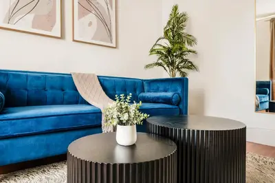 a living room with a blue couch and a table with flowers at 69-4D Trendy Lower East Side 1B BRAND NEW in New York
