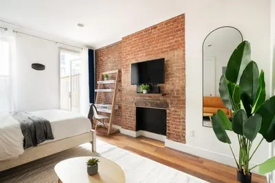 a bedroom with a brick wall with a fireplace at 24-4 New Private Terrace W D Apt Prime Gramercy in New York