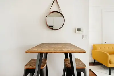 a dining room table with a mirror and a yellow chair at 24-4 New Private Terrace W D Apt Prime Gramercy in New York