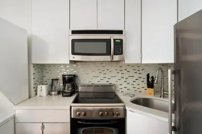 a kitchen with a stove and a microwave at 24-4 New Private Terrace W D Apt Prime Gramercy in New York