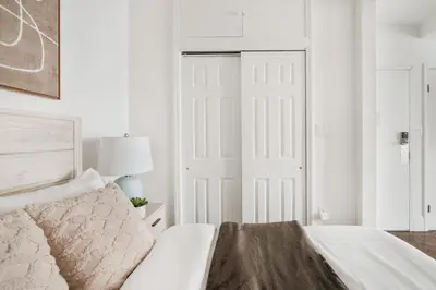 a bedroom with a white bed and a white door at 69-5B I Stylish Lower East Side 1BR Apt BRAND NEW in New York