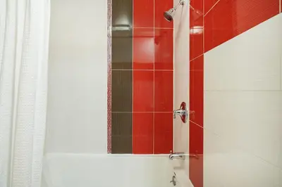a bathroom with a shower with red tile at 24-5 Furnished Studio W D Prime Gramercy in New York