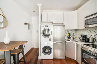 a kitchen with stainless steel appliances and a wooden table at 24-5 Furnished Studio W D Prime Gramercy in New York