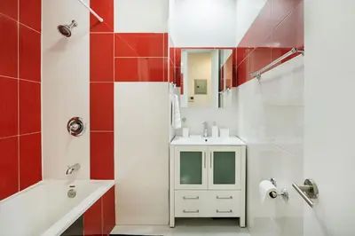 a bathroom with a sink and a tub and a mirror at 24-5 Furnished Studio W D Prime Gramercy in New York