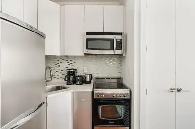 a kitchen with a stove and a microwave at 24-5 Furnished Studio W D Prime Gramercy in New York
