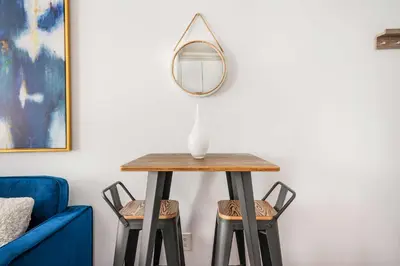 a table with a mirror on top of two stools at 24-5 Furnished Studio W D Prime Gramercy in New York