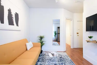 a living room with a couch and a mirror at 69-5D Modern Lower East East 1br Apt BRAND NEW in New York