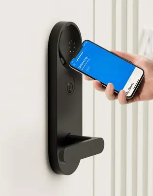 a person holding a cell phone in front of a door at 809-2A Gorgeous 1BR New W D Modern Best Location in New York