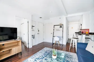 a living room with a blue couch and a tv at 809-3A 1BR Columbus Circle Elevator W D in New York