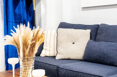 a blue couch with pillows and a vase on a table at 809-3B Columbus Circle W D new BLDG Balcony in New York
