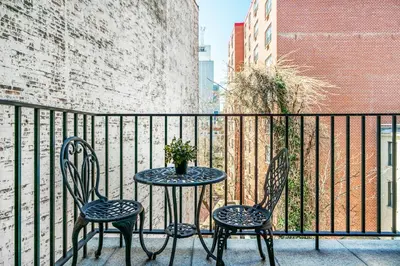 a table and chairs on a balcony with a fence at 809-4B Studio Balcony W D Prime location in New York