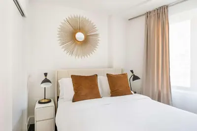 a white bedroom with a white bed and a mirror at 809-4B Studio Balcony W D Prime location in New York