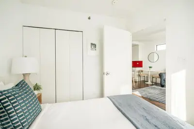 a white bedroom with a bed and a living room at 809-5A Gorgeous New 1BR Heart of Midtown in New York