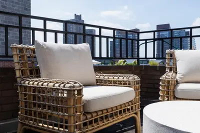 a wicker chair sitting on top of a balcony at 809-6A NEW 2BR Private Roof & City View in New York