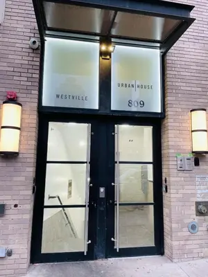 a store front with glass doors on a brick building at 809-6A NEW 2BR Private Roof & City View in New York