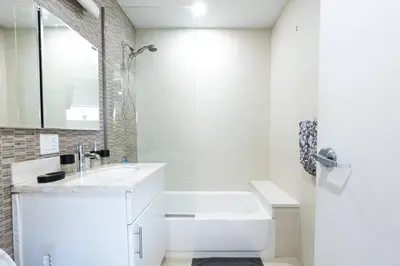 a white bathroom with a tub and a sink at 809-6B 2BR Duplex Breathtaking Views Beauty in New York