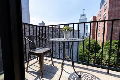 a small table and a chair on a balcony at 809-6B 2BR Duplex Breathtaking Views Beauty in New York