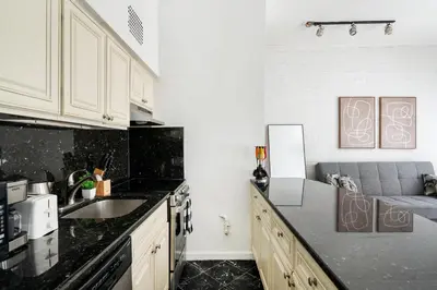 a kitchen with a sink and a couch in it at 26-2B Gramercy Large 1BR WD in unit courtyard in New York