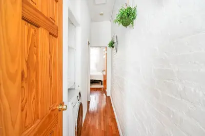 a hallway with a white wall and a door at 26-2B Gramercy Large 1BR WD in unit courtyard in New York