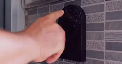 a person holding a black remote control on a wall at 26-2B Gramercy Large 1BR WD in unit courtyard in New York