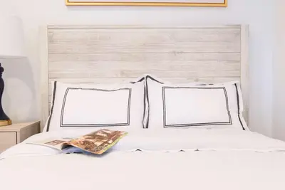 two white pillows on a white bed with two frames at 69-5A Modern Lower East Side 1BR Apt BRAND NEW in New York