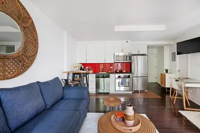a living room with a blue couch and a kitchen at 809-2B New bldg Jr columbus circle Balcony WD in New York