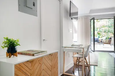 a white kitchen with a desk and a chair at 809-2B New bldg Jr columbus circle Balcony WD in New York