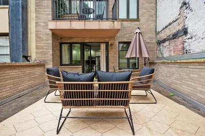 two chairs and an umbrella in front of a building at 809-2B New bldg Jr columbus circle Balcony WD in New York